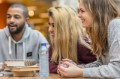 Multi ethnic university adult students learning languages together in a public library