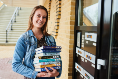 Een jonge vrouw bezorgt boeken aan de voordeur