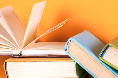 Decoratieve afbeelding: stapel boeken met een oranje achtergrond